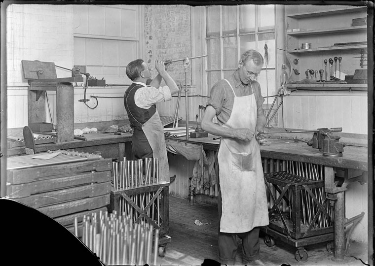 Two Armory workers star gauging rifles to inspect the rifling of the barrel