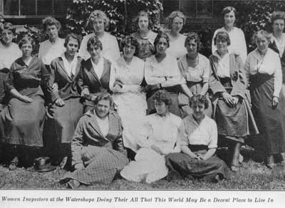 group photo, 18 women in long skirts in front of ivy-covered building, caption:“Women Inspectors at the Watershops Doing Their All That This World May Be a Decent Place to Live In.”